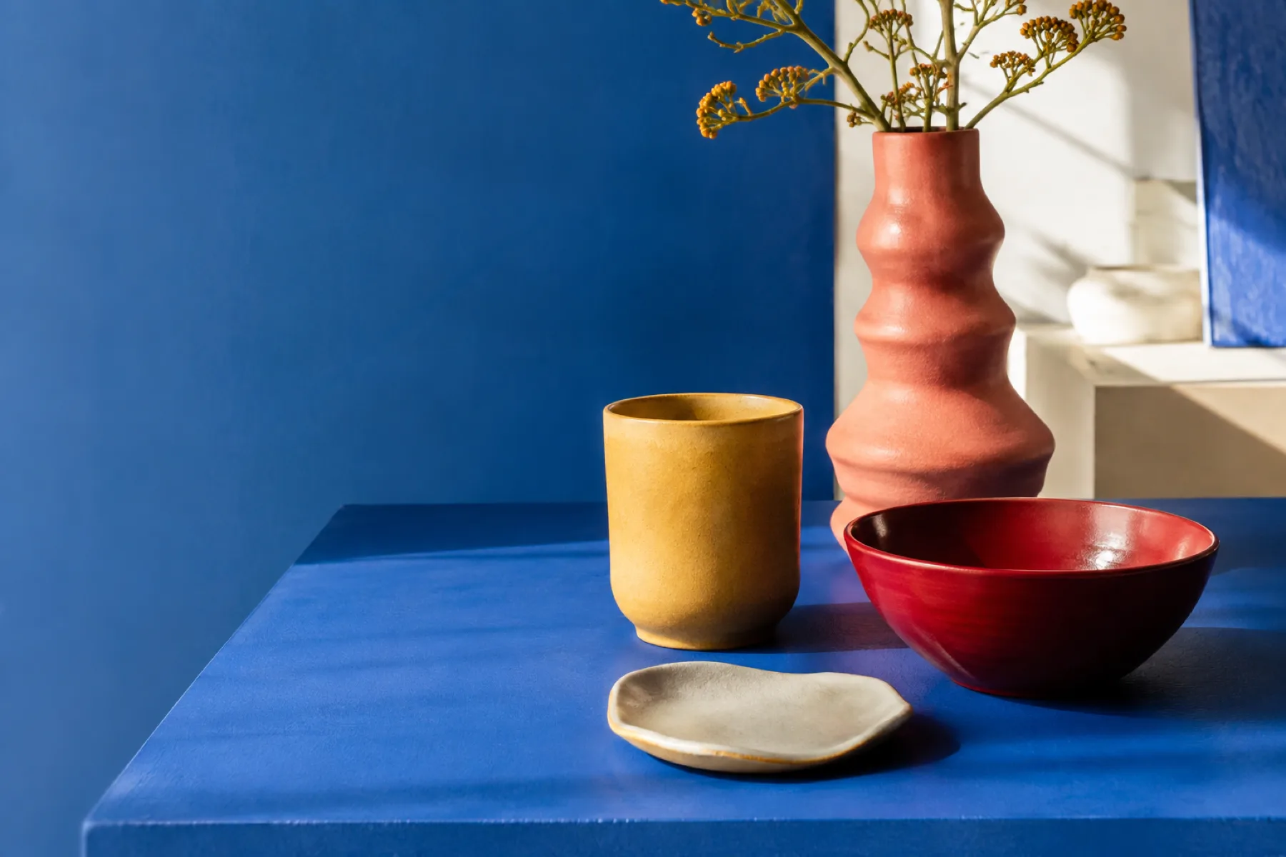 Pièces de céramique colorées posées sur une table bleue